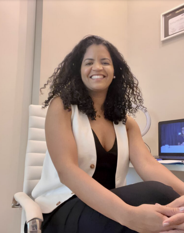 Psicóloga Patrícia Furtado sorrindo em seu consultório